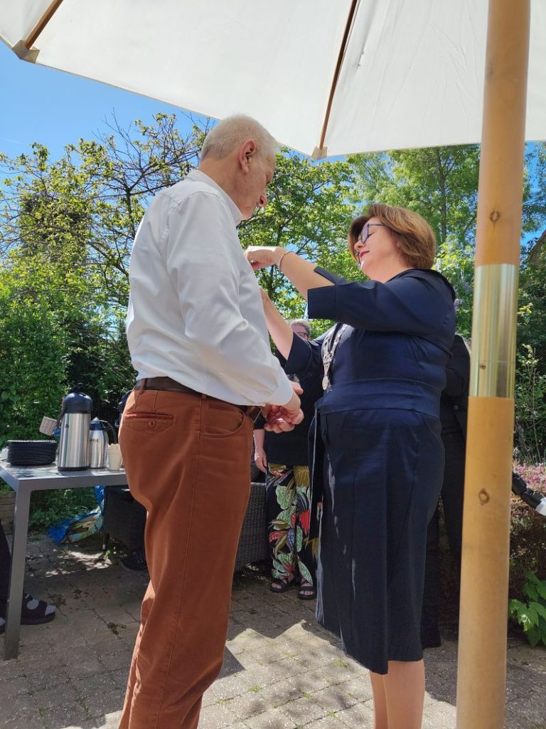 de burgemeester spelt het lintje op